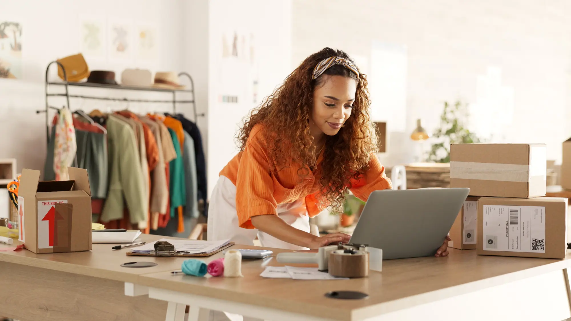 Logistics, laptop and fashion manager of retail or boutique shop checking clothing stock in boxes on a checklist