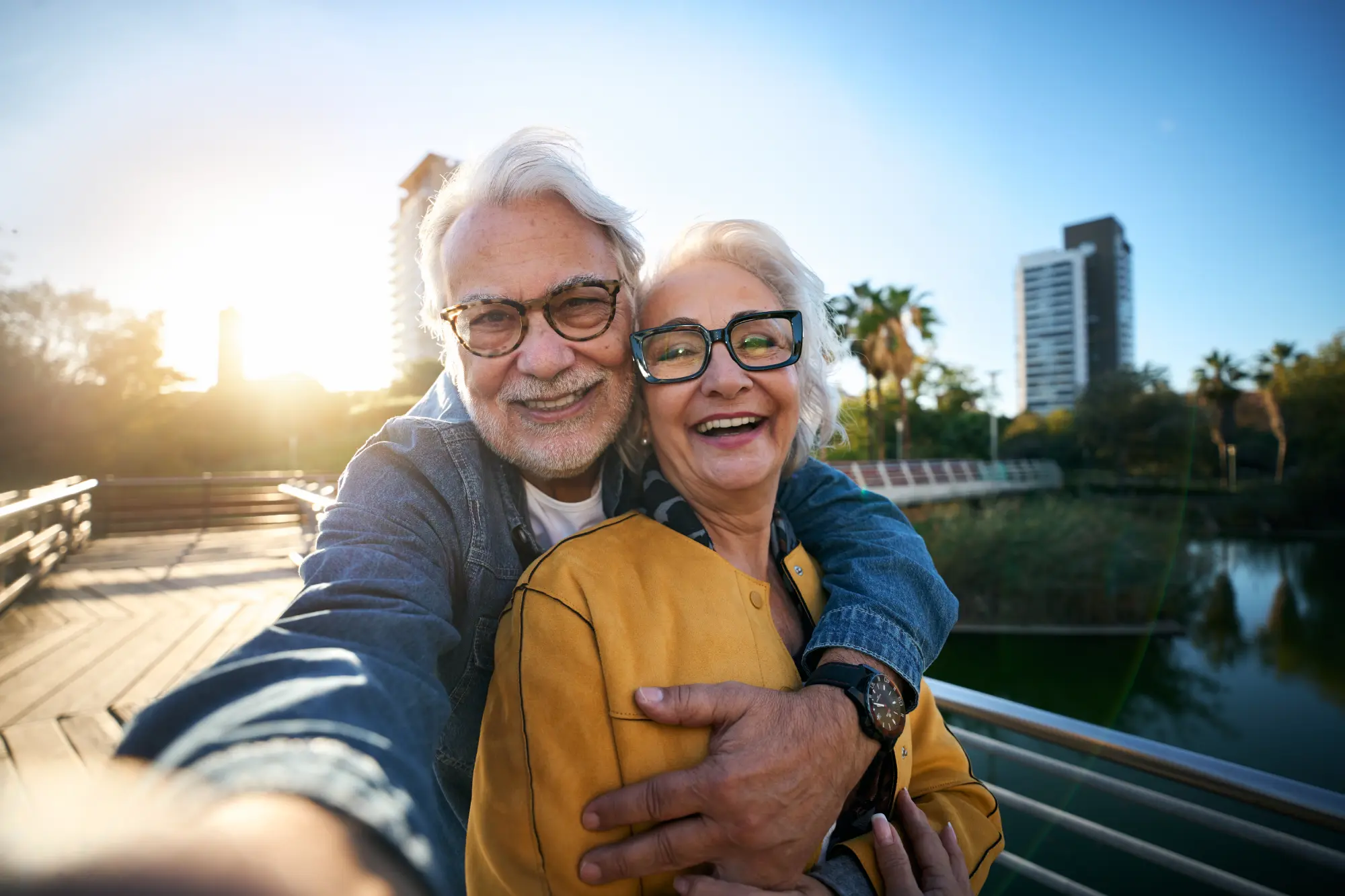 Portrait of happy senior couple taking selfie outdoors in a park of the city